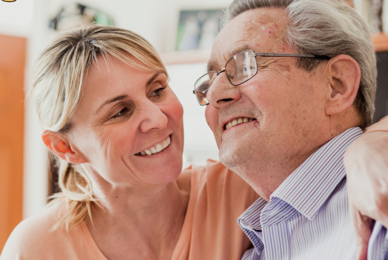 A smiling woman and an elderly man share a joyful moment together at home.